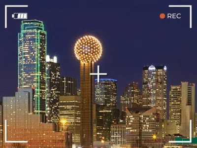 skyline of dallas at night overlaid with a camera viewfinder